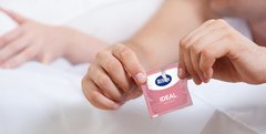 Paar packt Kondom aus